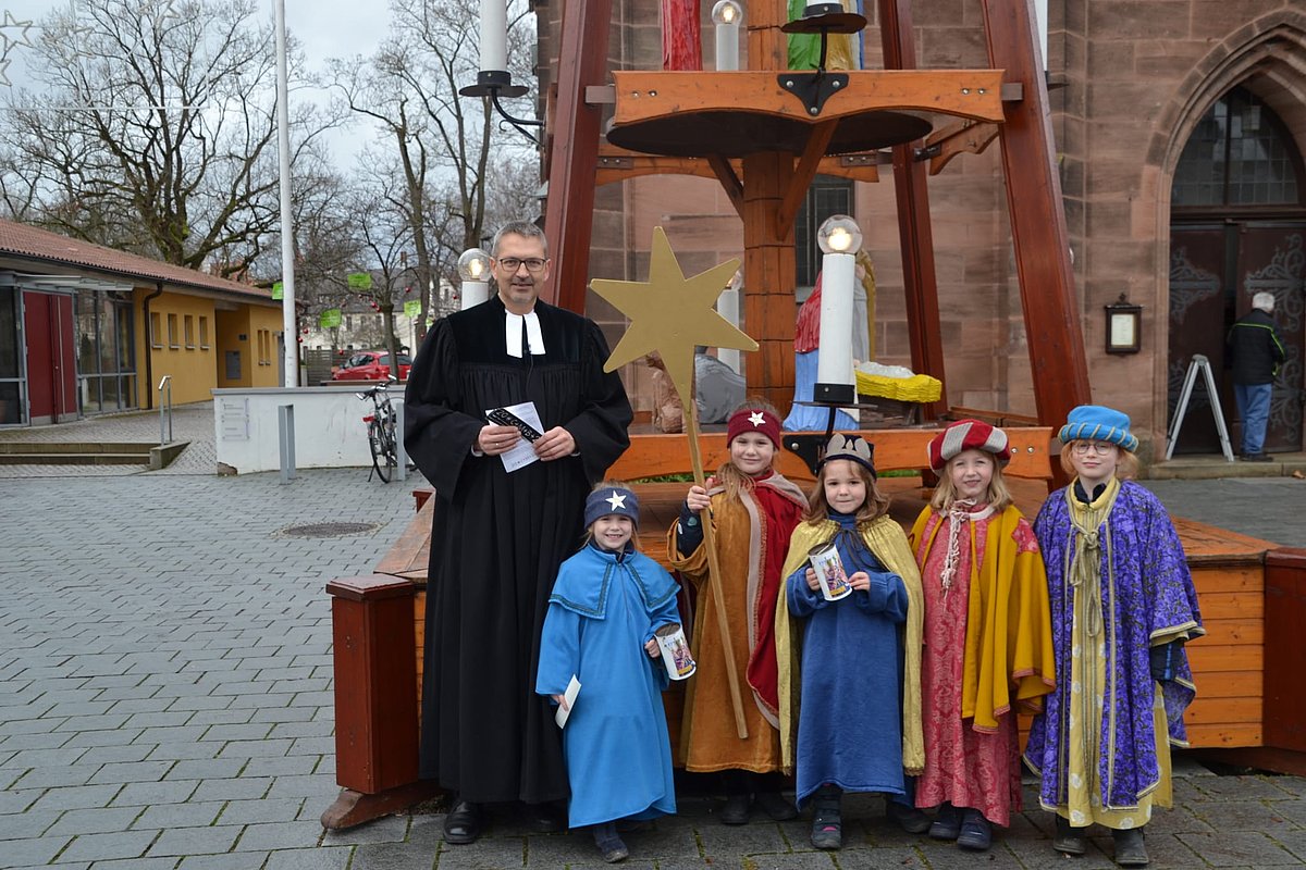 Sternsinger und Pfarrer vor Kirche Sternsinger und Pfarrer vor Kirche