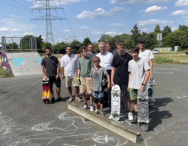 Menschen stehen auf einer  Skateboardanlage