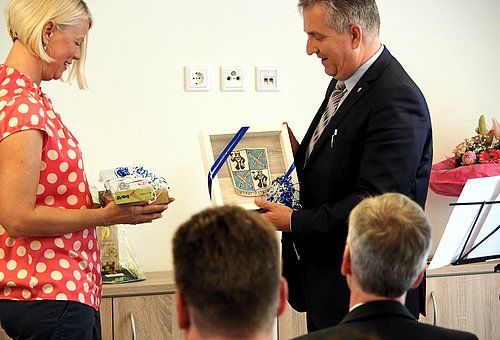 Die Einrichtungsleiterin Simone Whitfild bekommt von Ersten Bürgermeister Kurt Krömer ein Geschenk überreicht