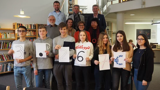 Schülerinnen und Schüler halten Schilder in der Hand, auf denen die Spendensumme von 3267 Euro zu lesen ist. Das Geld spendeten sie an den Sozialverein Lichtblick.
