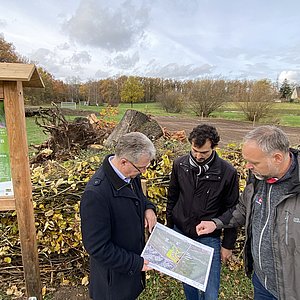 Drei Personen stehen auf einer Wiese