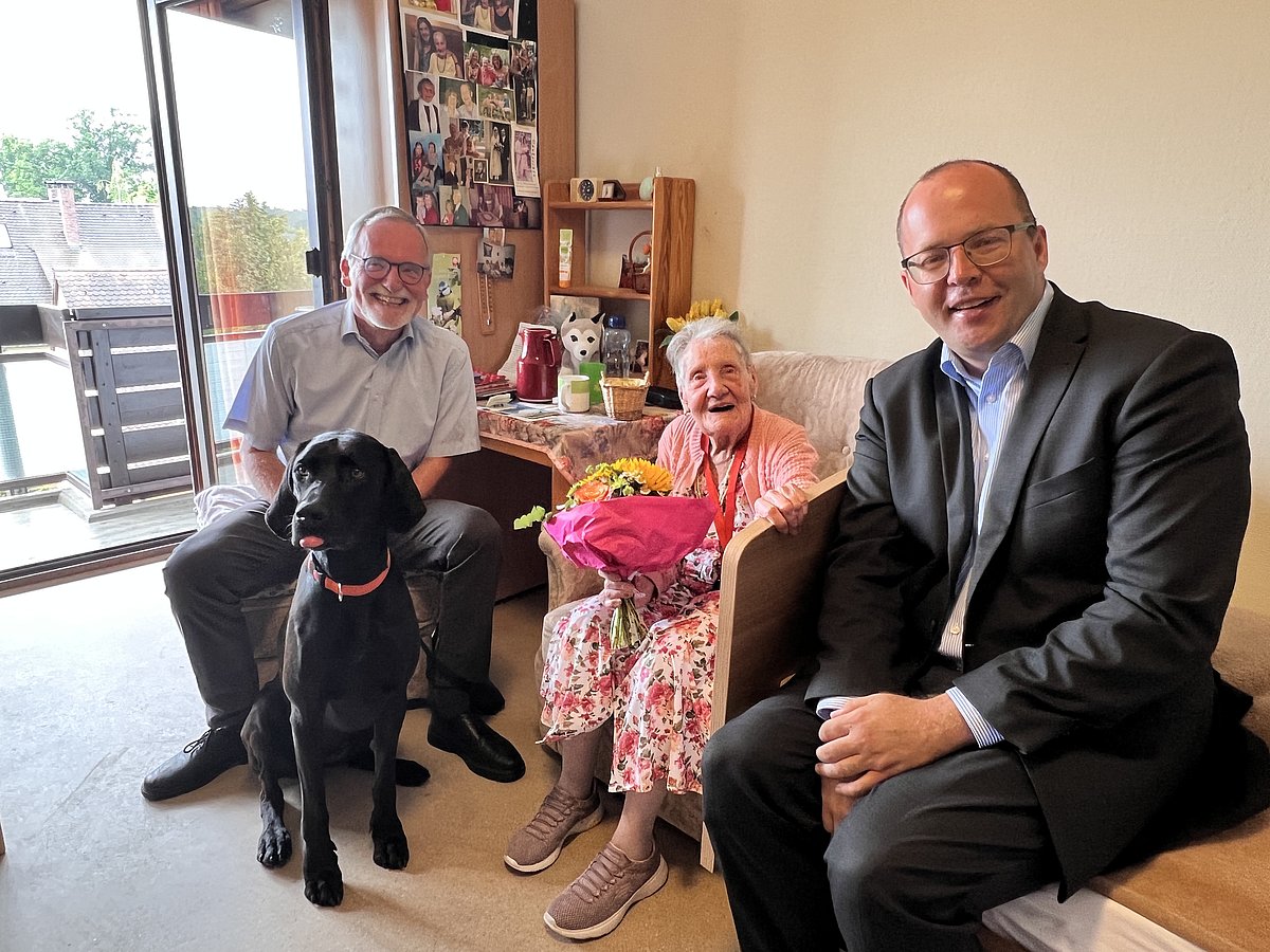 Der stellvertretende Landrat Franz Xaver Forman (links) und Zweiter Bürgermeister Bertram Höfer (r.) gratulieren Ursula Kahl zum 103. Geburtstag. Mit dabei war auch Familienhündin Juya. Foto: Stadt Stein