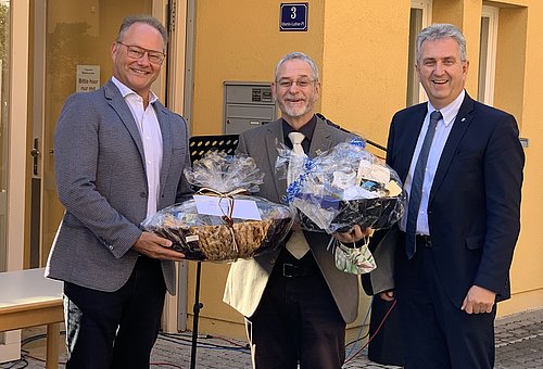 Klaus Heinrich (Vorstand des Kommunalbetrieb Stein) und Erster Bürgermeister Kurt Krömer überreich Pfarrer Jochen Ackermann Geschenke