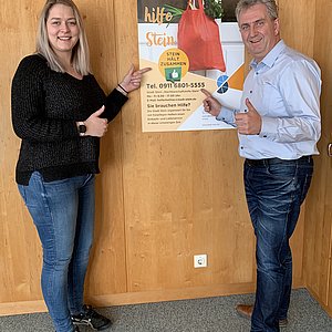 Carina Gietl vom Sozialamt und Bürgermeister Kurt Krömer präsenterieren das Plakat zur Aktion Nachbarschaftshilfe