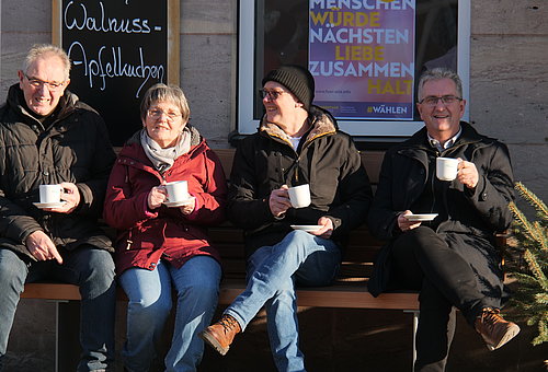 Personen sitzen auf einer Bank